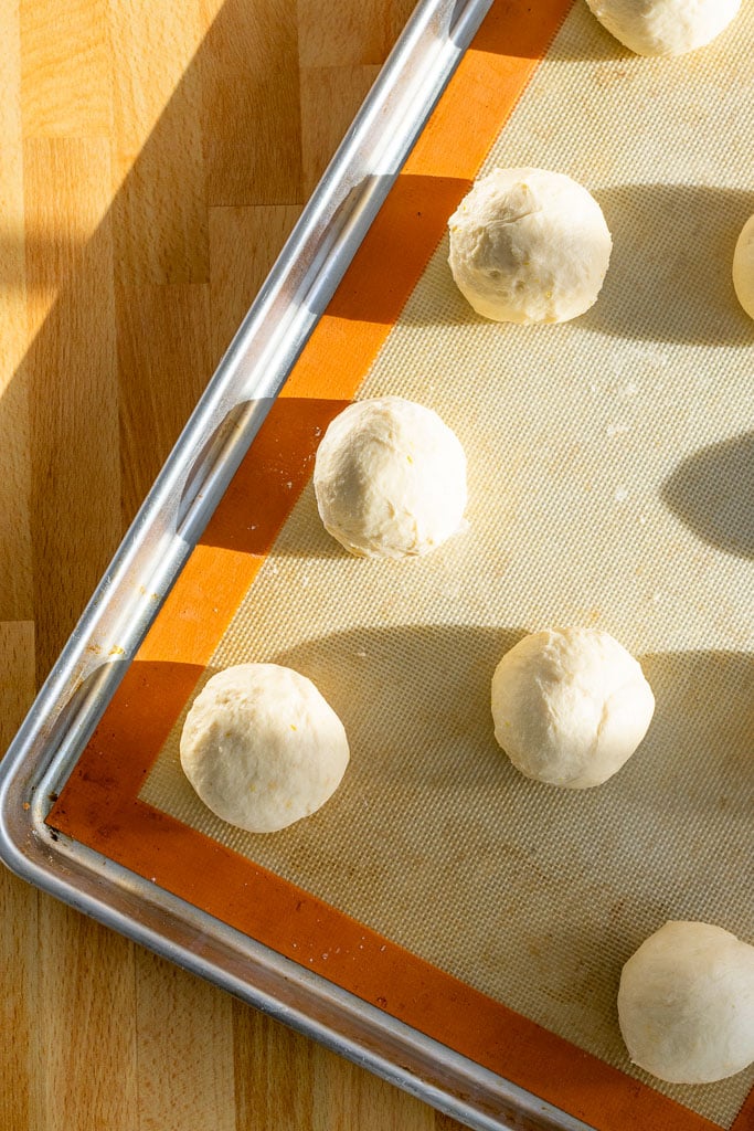 Sourdough maritozzi on a baking sheet at the start of proofing