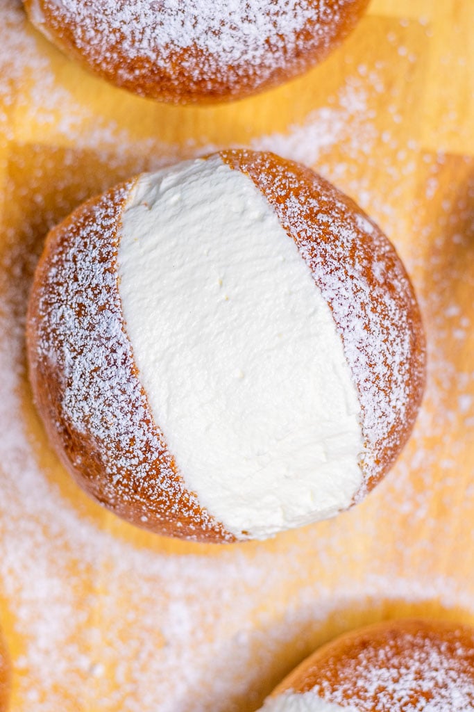 Close up of a sourdough maritozzo filled with whipped cream and dusted with powdered sugar
