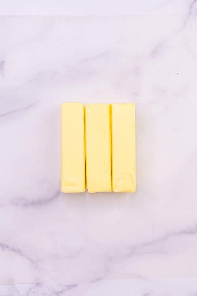 Three sticks of butter on parchment paper