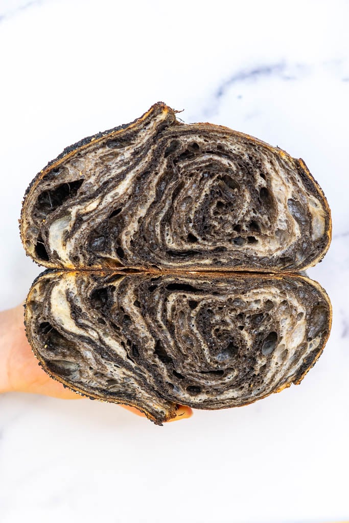 Hand holding a Black Sesame Sourdough Bread sliced in half