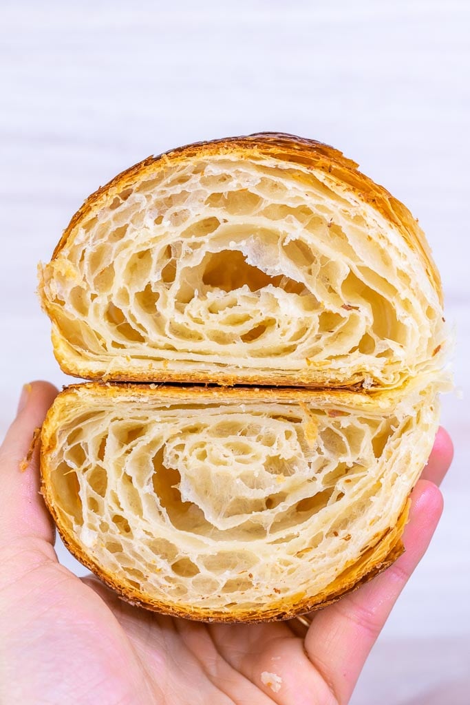 Hand holding a honeycomb interior sourdough croissant