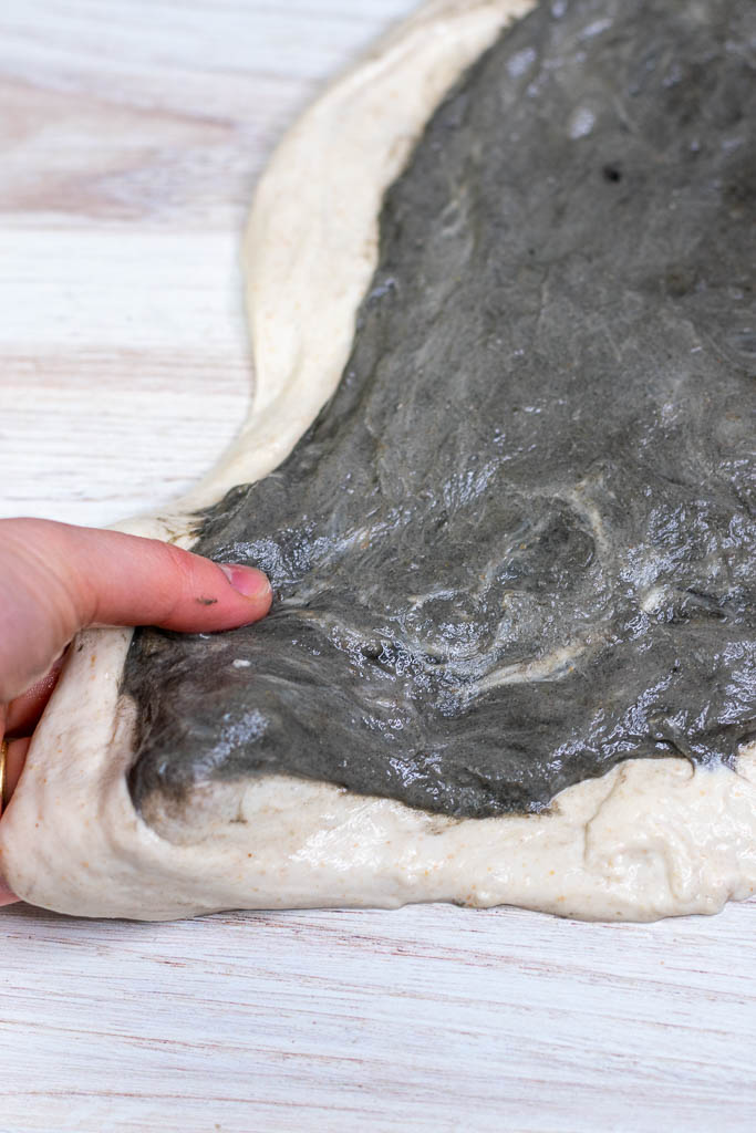 Wet hand stretching the dough to be larger.