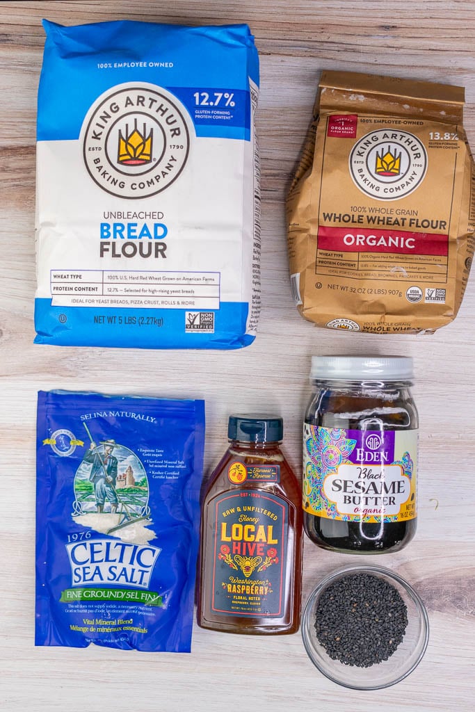 Ingredients needed for black sesame sourdough bread including bread flour, whole wheat flour, salt, honey, black sesame paste, and black sesame seeds