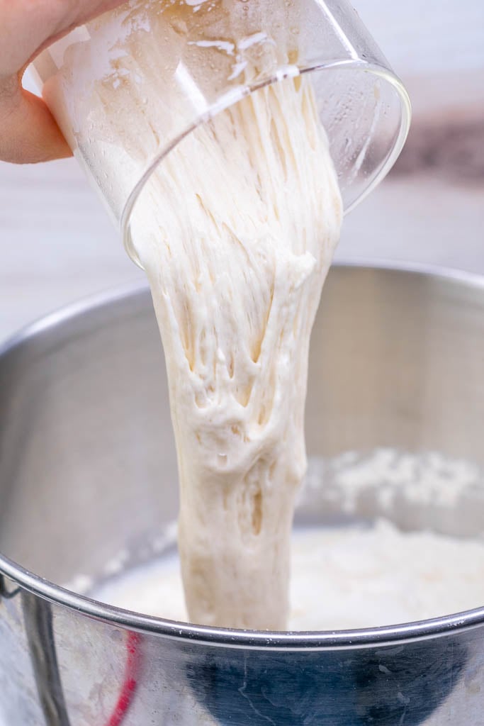 Pouring sourdough starter to dough