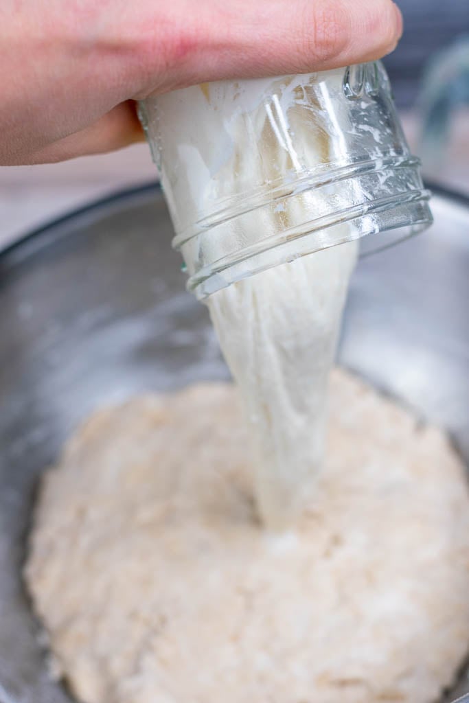 Pouring levain into bowl for mixing