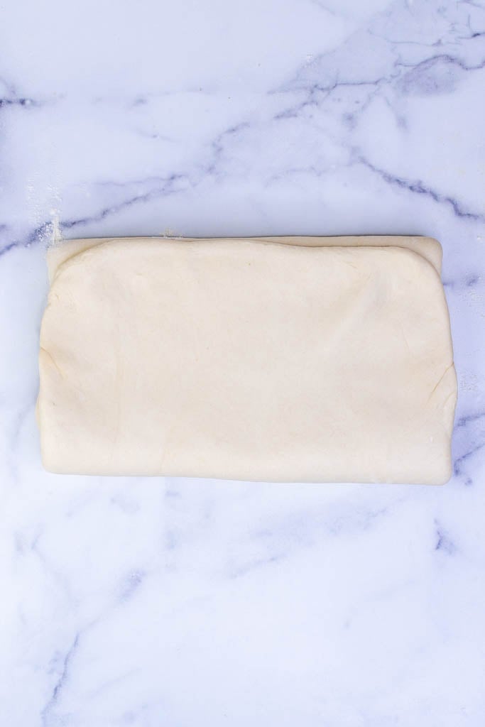 Bottom third of dough folded over to create a letter packet