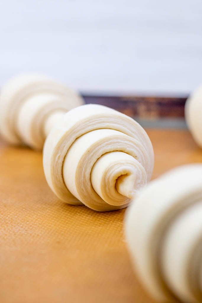 Visible layers of a sourdough croissant on a baking sheet at the start of proofing
