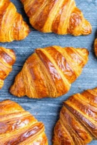 Sourdough croissants on a wood surface.
