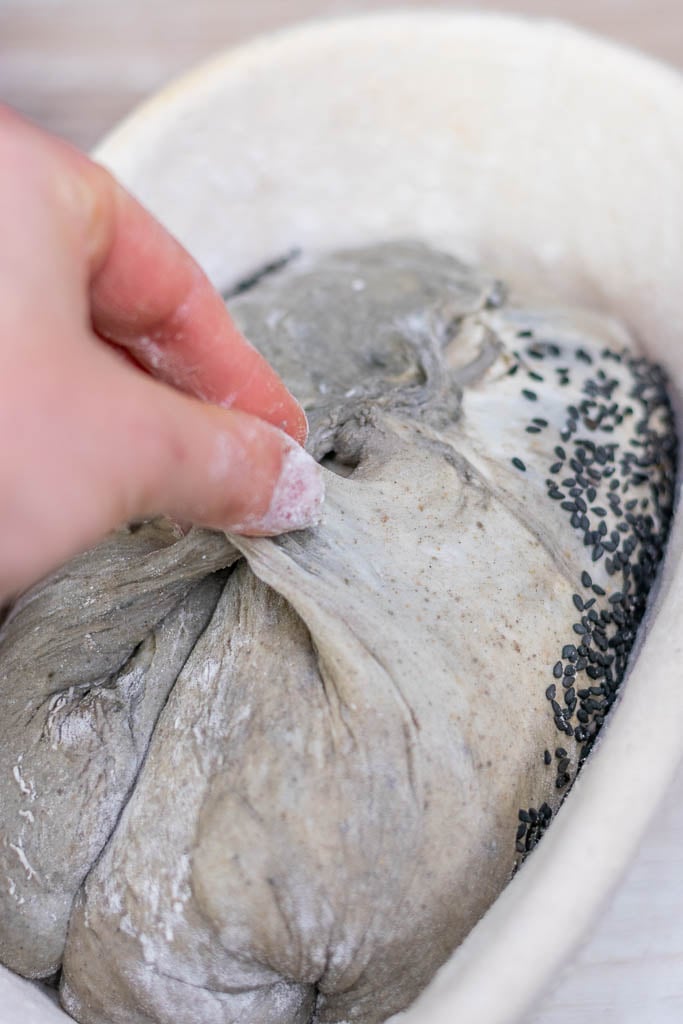 Stitching black sesame sourdough in banneton