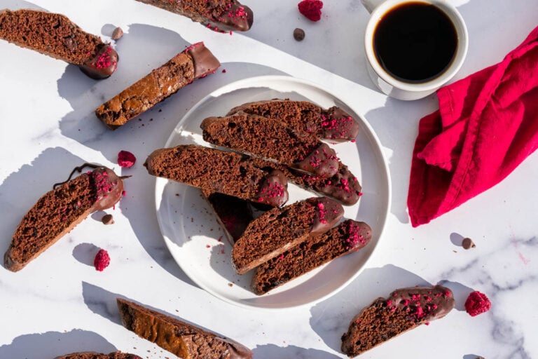Chocolate Raspberry Sourdough Biscotti on a plate with a cup of coffee