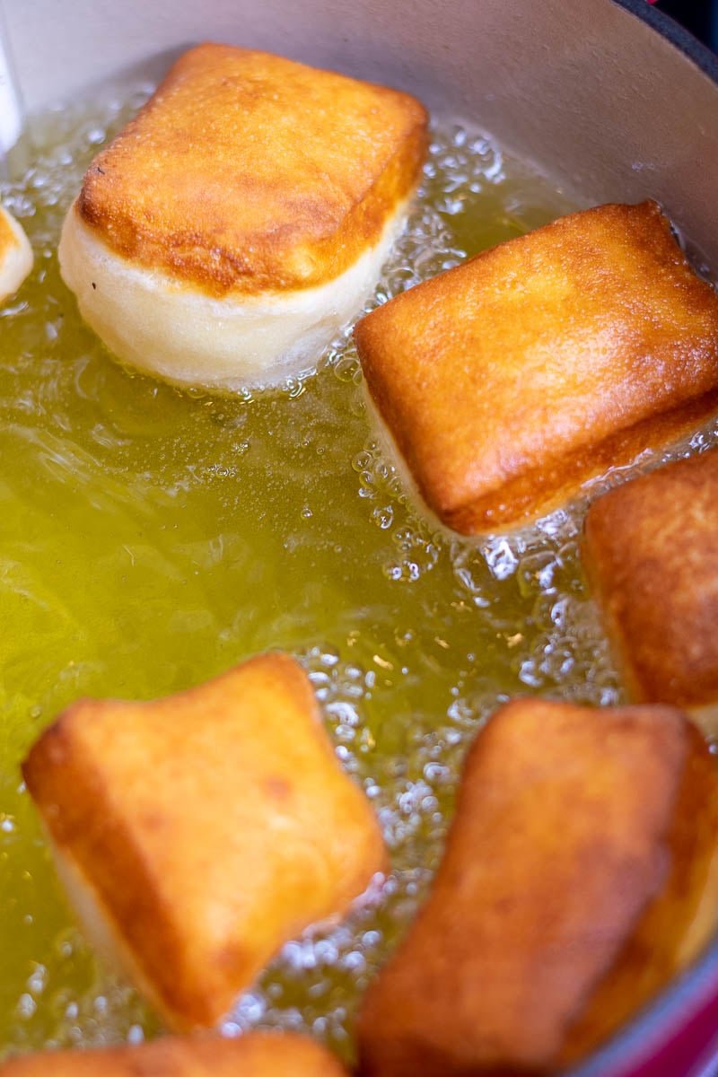 Sourdough beignets just flipped over in pot of oil.