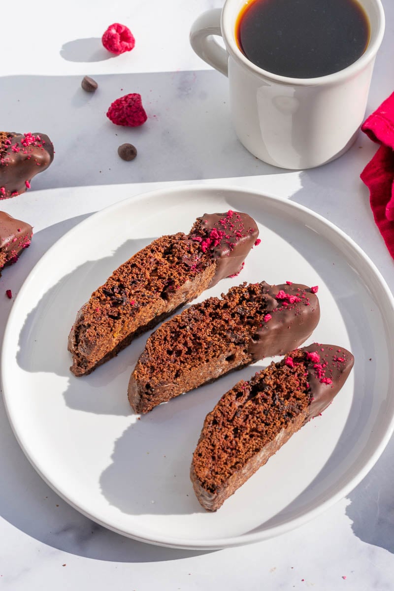 Plate of chocolate raspberry sourdough biscotti with a coffee