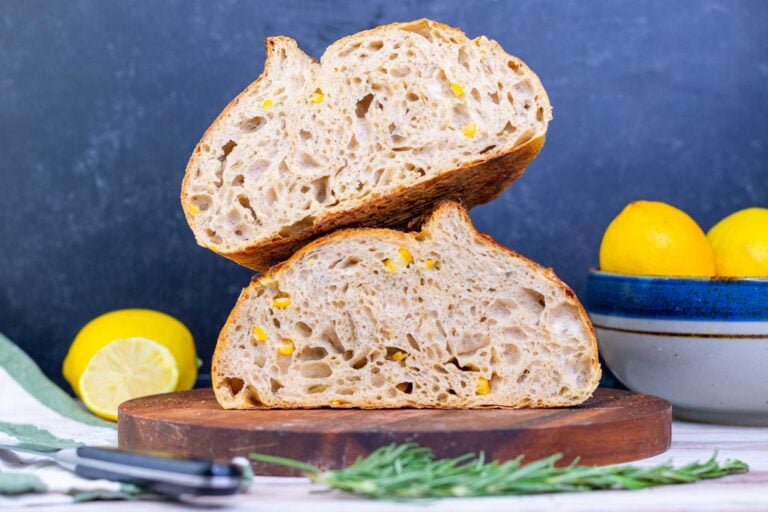 Preserved lemon and rosemary sourdough bread stacked on top of each other on a cutting board
