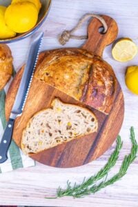 Slice of preserved lemon and rosemary sourdough bread on a cutting board