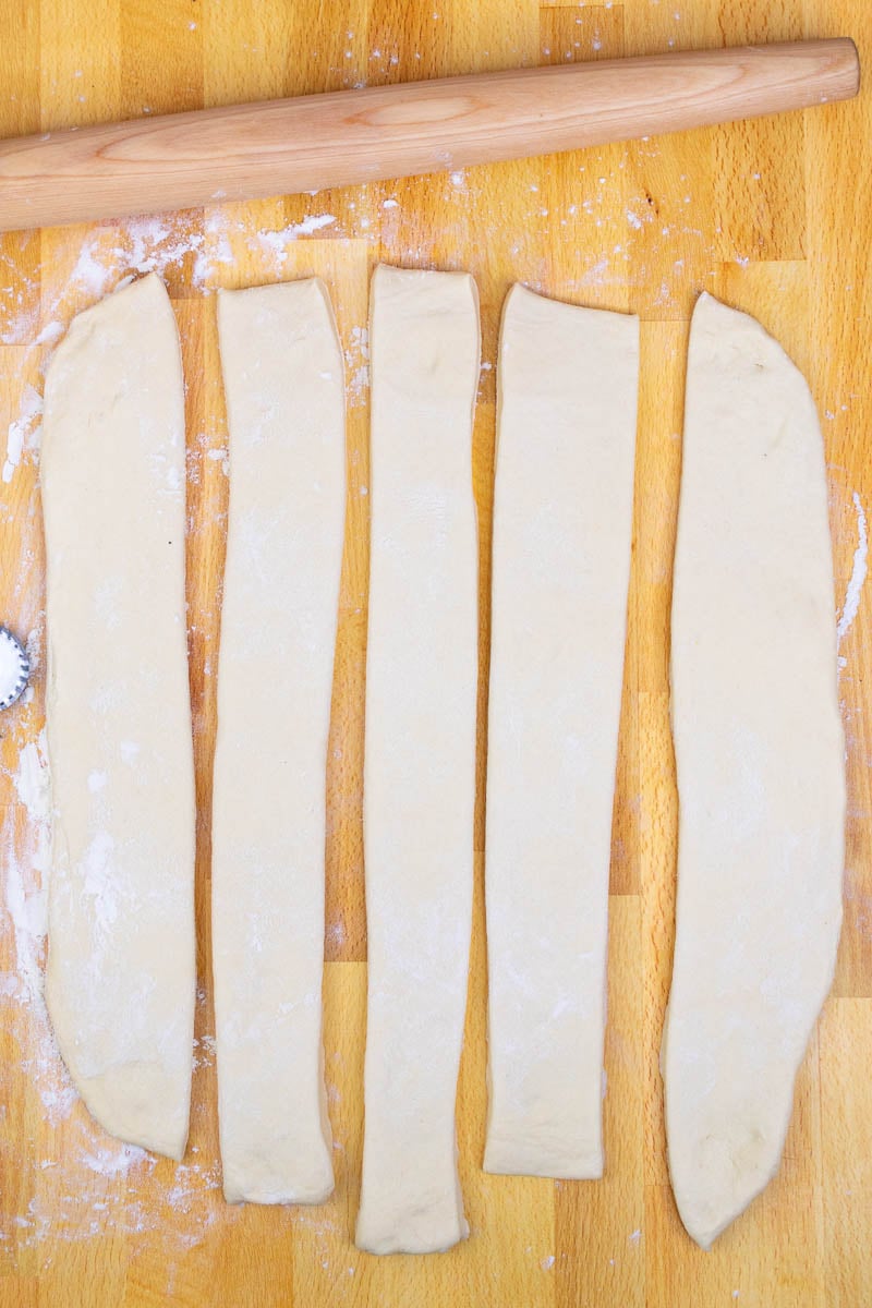 The dough is cut into five long slices on the counter.