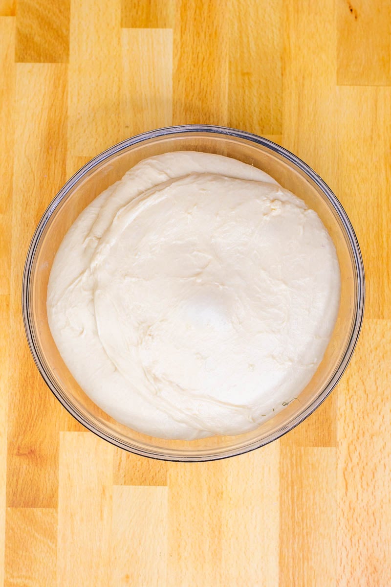 Beignet dough doubled in size in bowl at the end of proofing