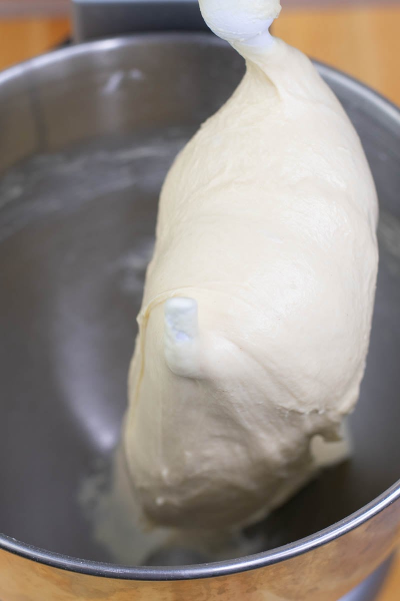 Beignet dough in mixing bowl after 10 minutes of mixing. It is supple, smooth, and clinging to the dough hook.