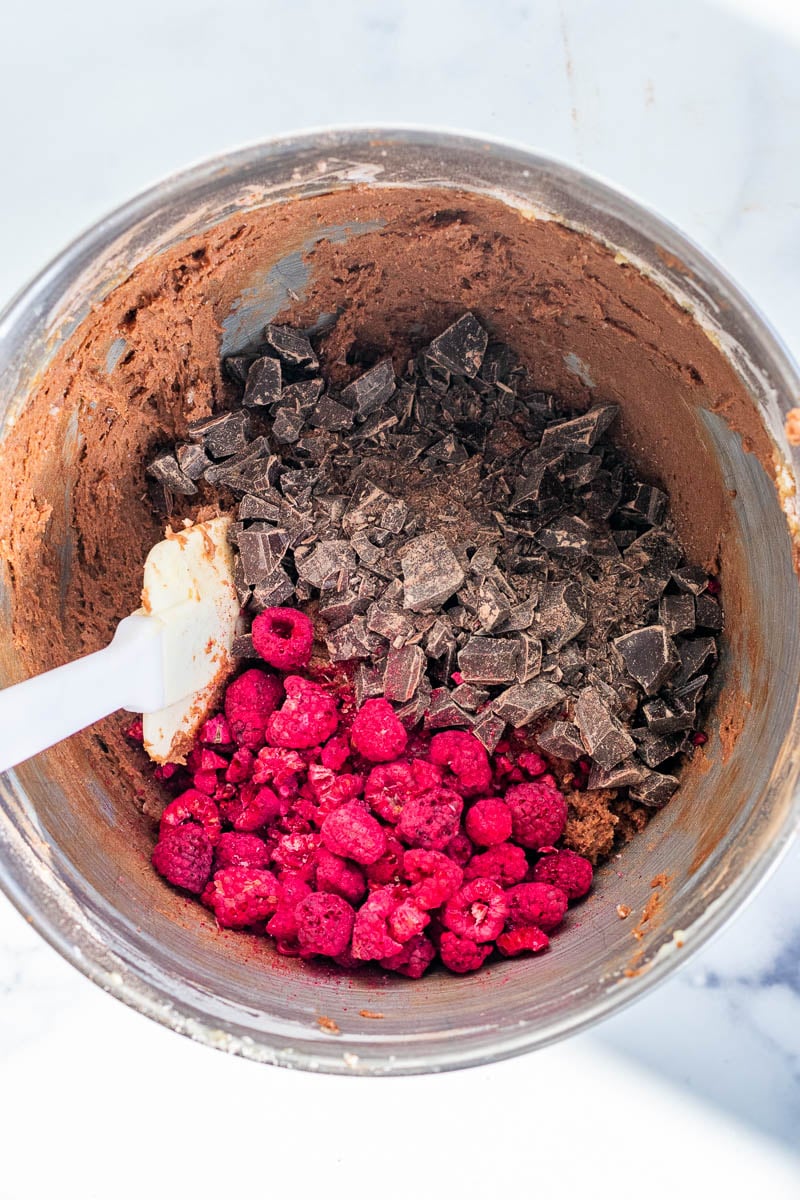 Chopped chocolate and freeze-dried raspberries in bowl with biscotti dough