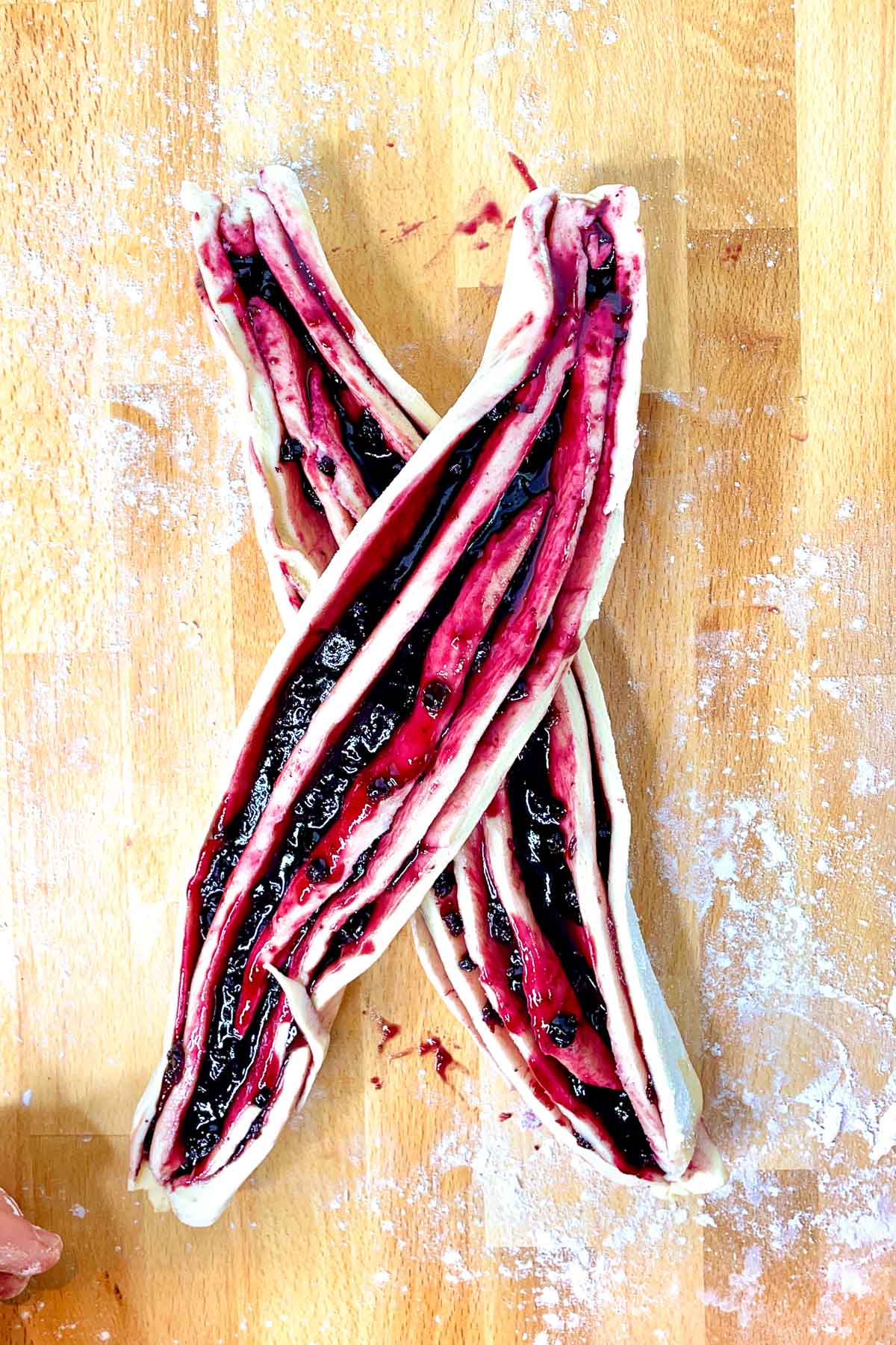 First step of braiding the babka. Create an X with the dough.