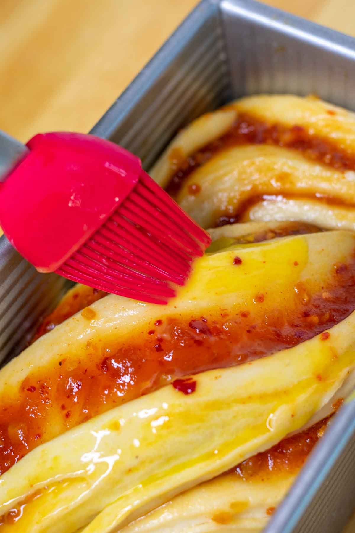 Brushing egg wash onto babka dough