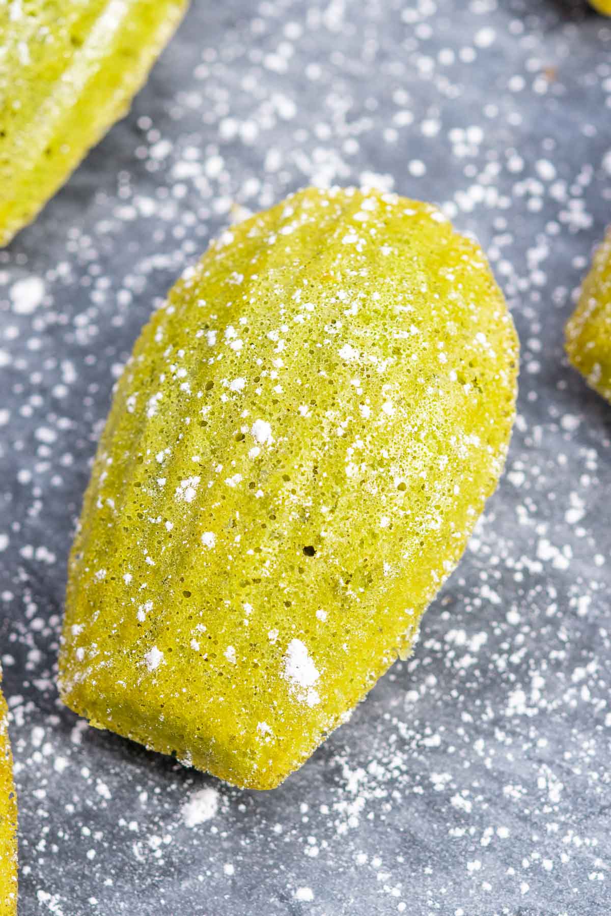 Sourdough matcha madeleine dusted with powdered sugar