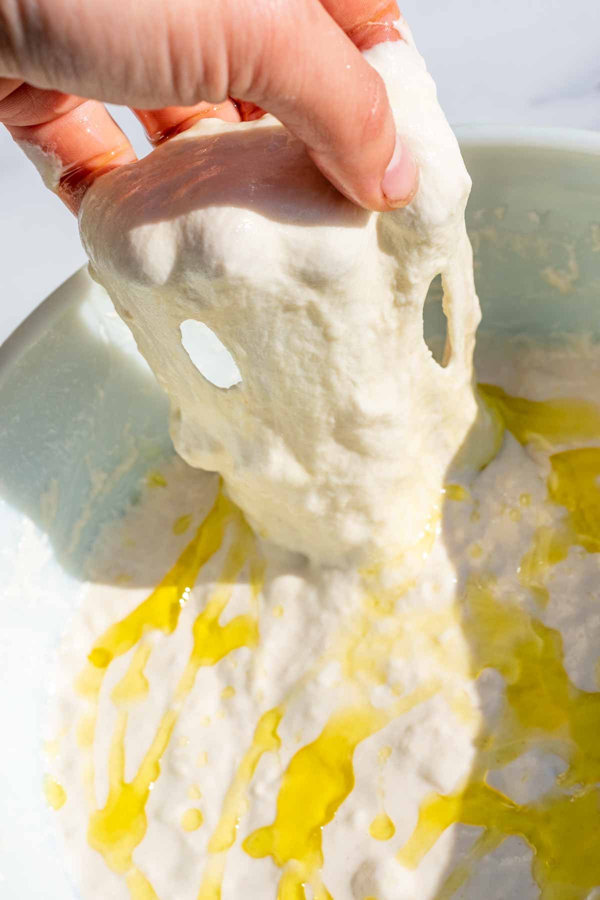 Hand stretching loose dough for first stretch and fold