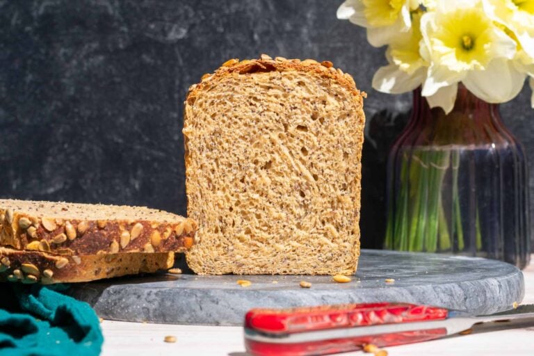 Slices of seeded whole wheat sourdough sandwich bread with bread knife