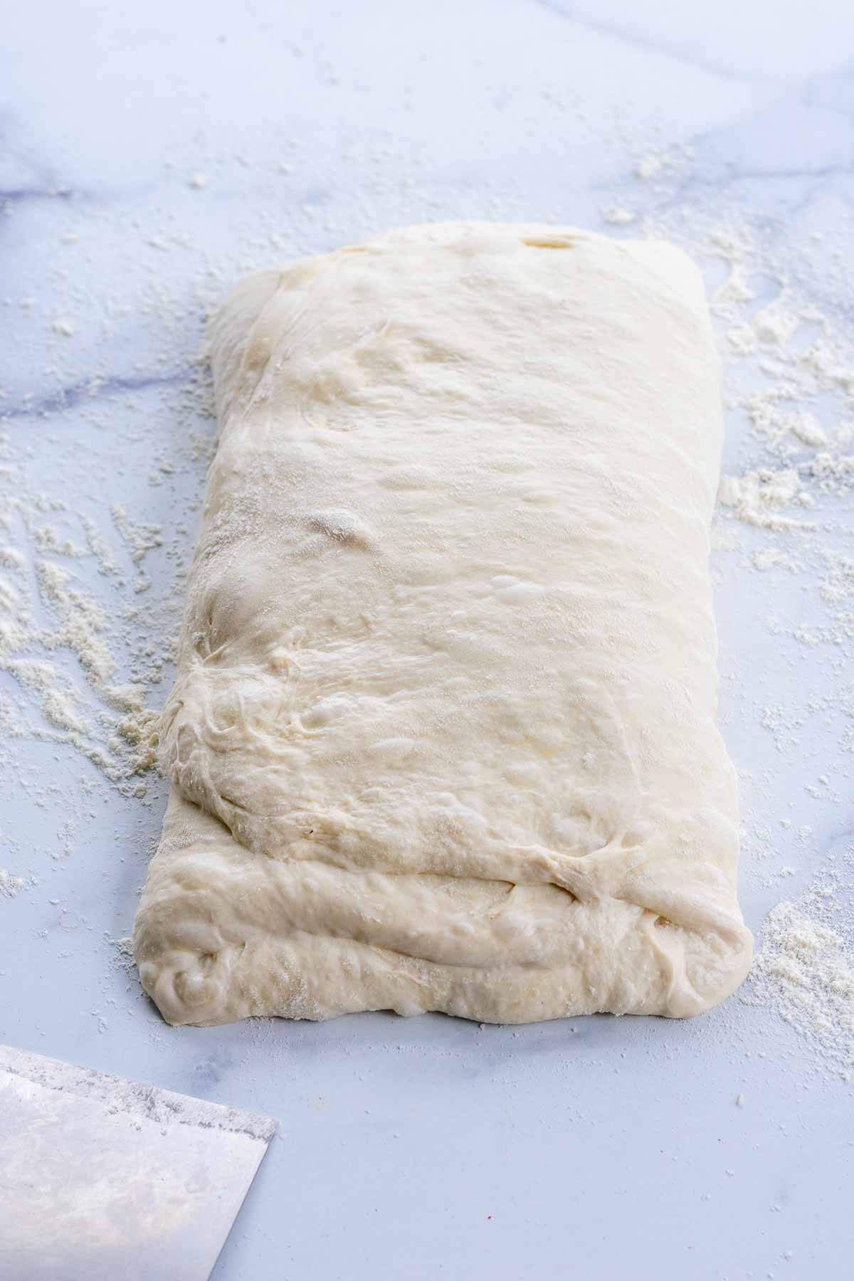 Shaped pan de cristal dough into a long rectangle letter