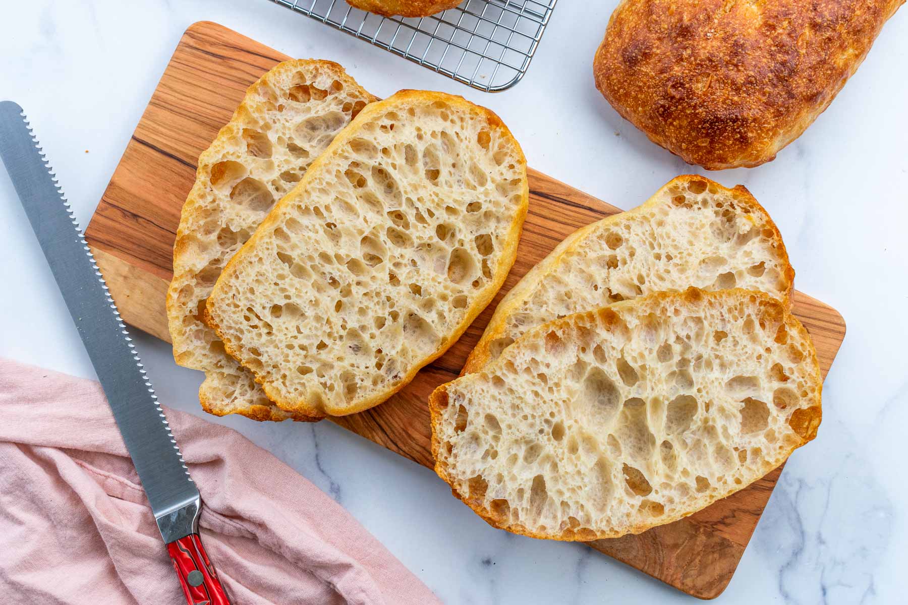 Slices of sourdough pan de cristal on a cutting board