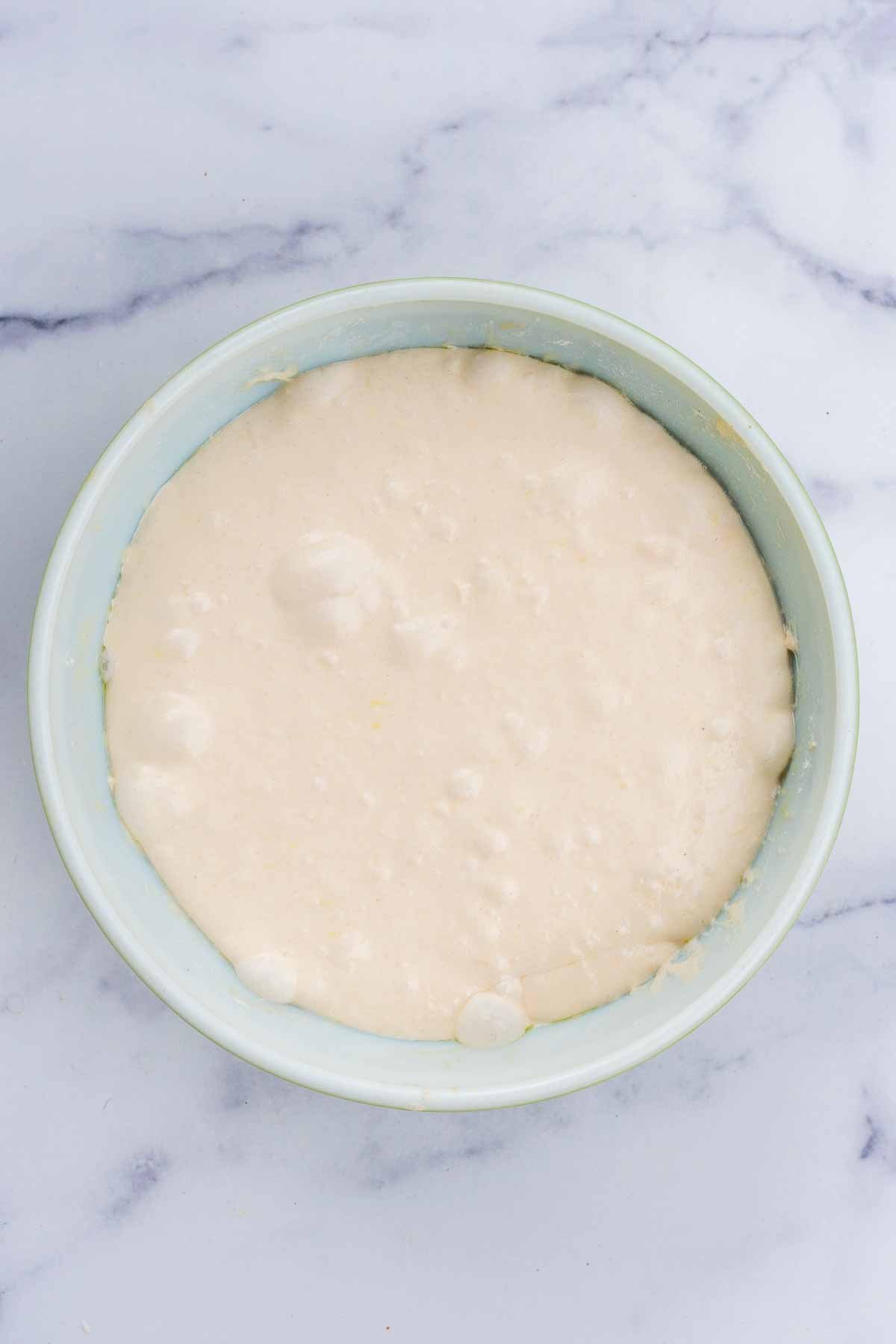 Pan de cristal dough in bowl at the end of bulk fermentation with many bubbles