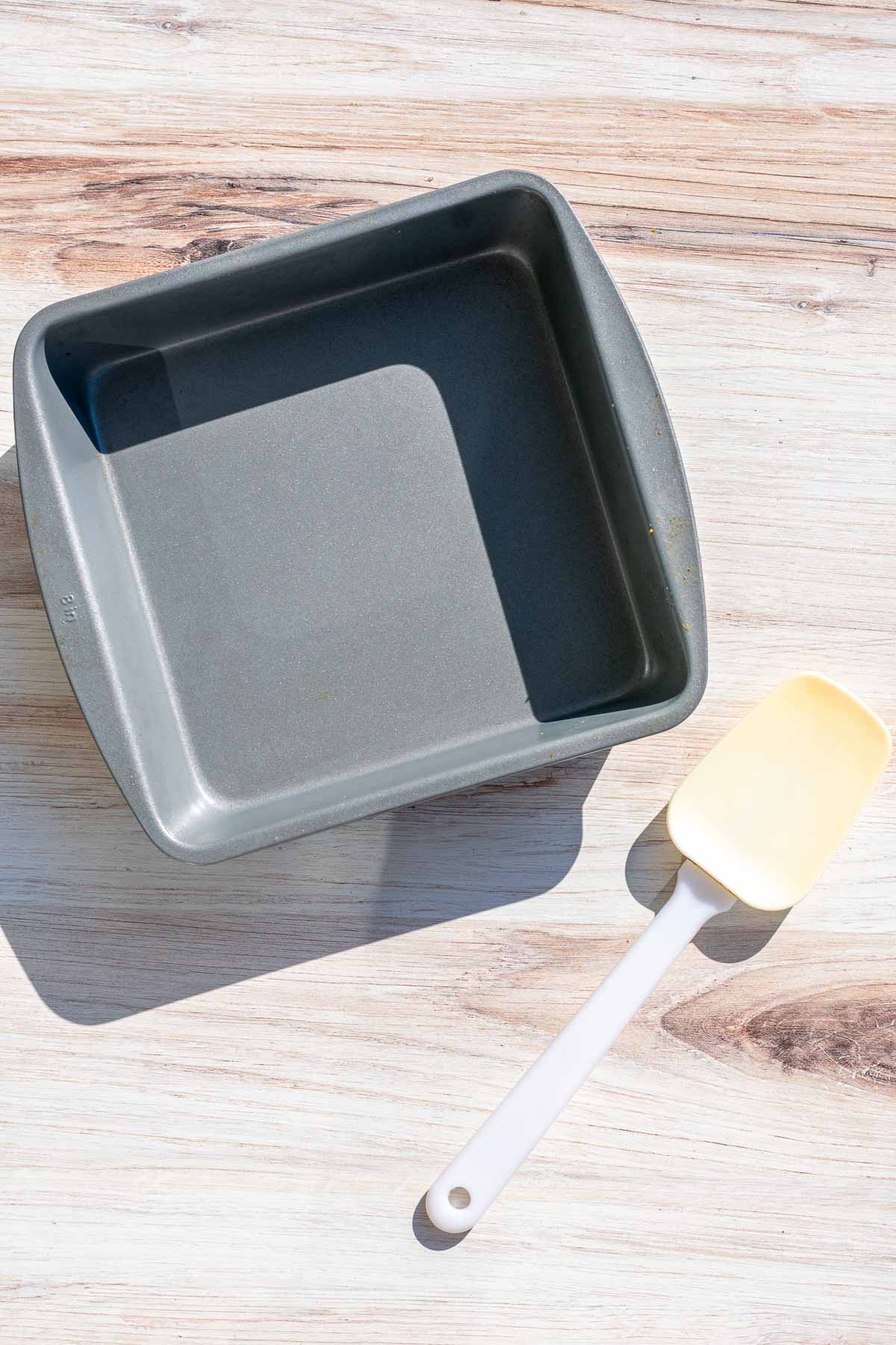 An 8-inch square baking pan and a spatula