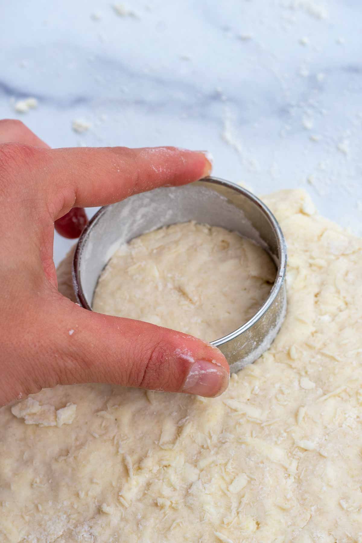 Cutting out round shortcakes with biscuit cutter