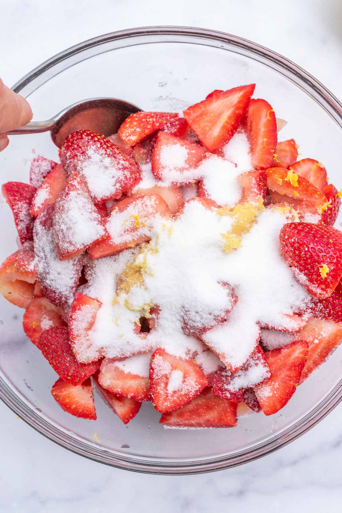 Bowl of strawberries with sugar and lemon zest