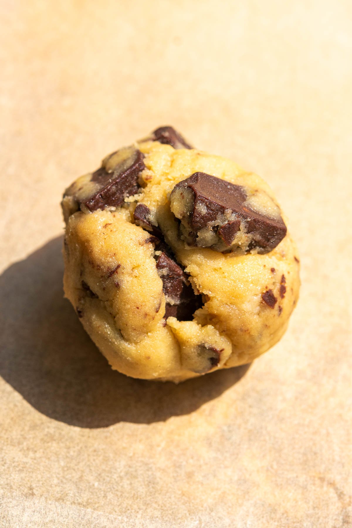 A close up of a ball of sourdough discard chocolate chip cookie dough.