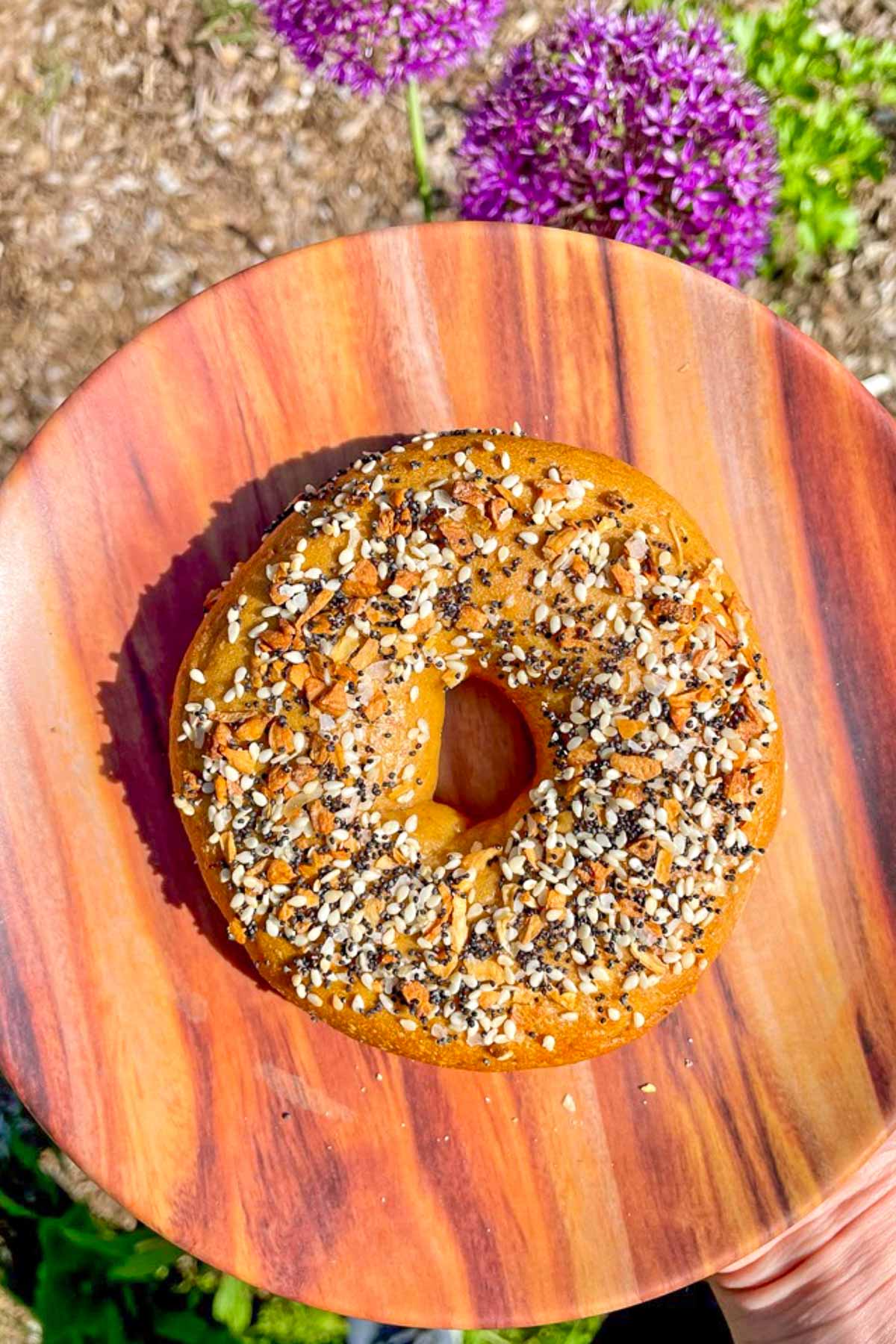 An everything sourdough bagel on a plate