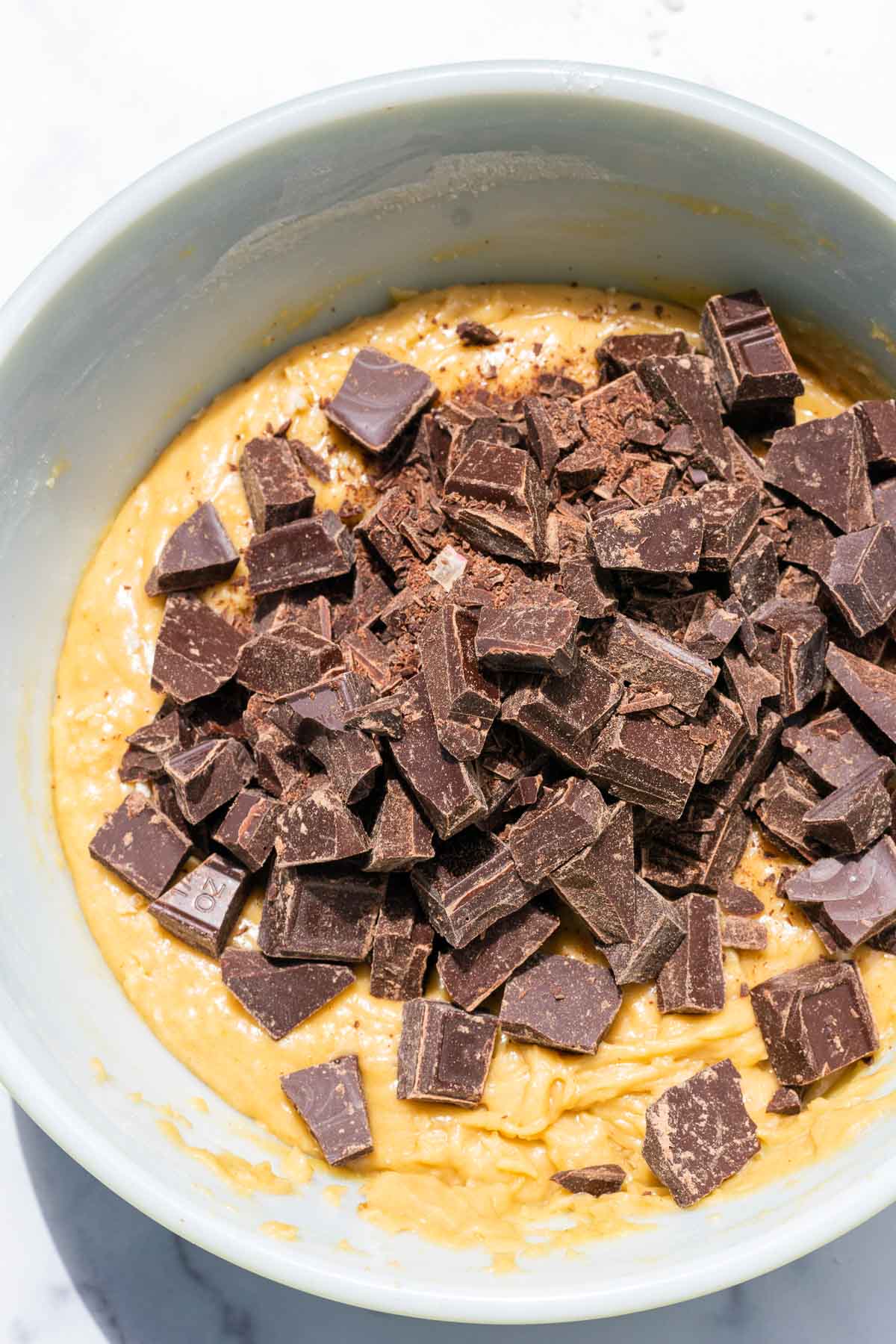Roughly chopped chocolate chunks added in bowl of cookie dough