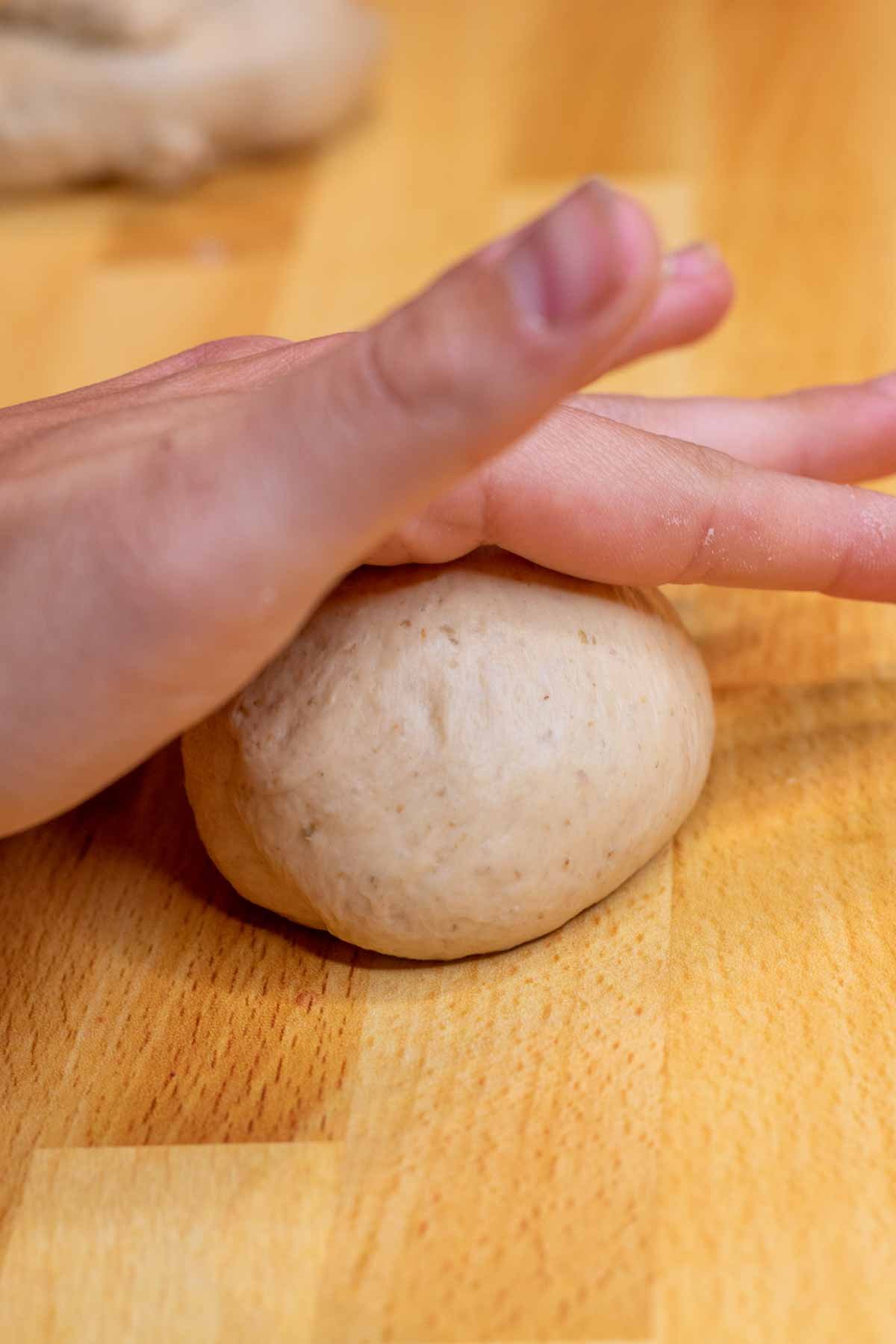 Hand rolling bagel dough into balls