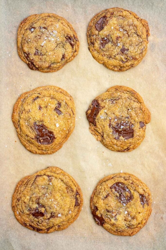 Sheet pan with six baked sourdough discard chocolate chip cookies