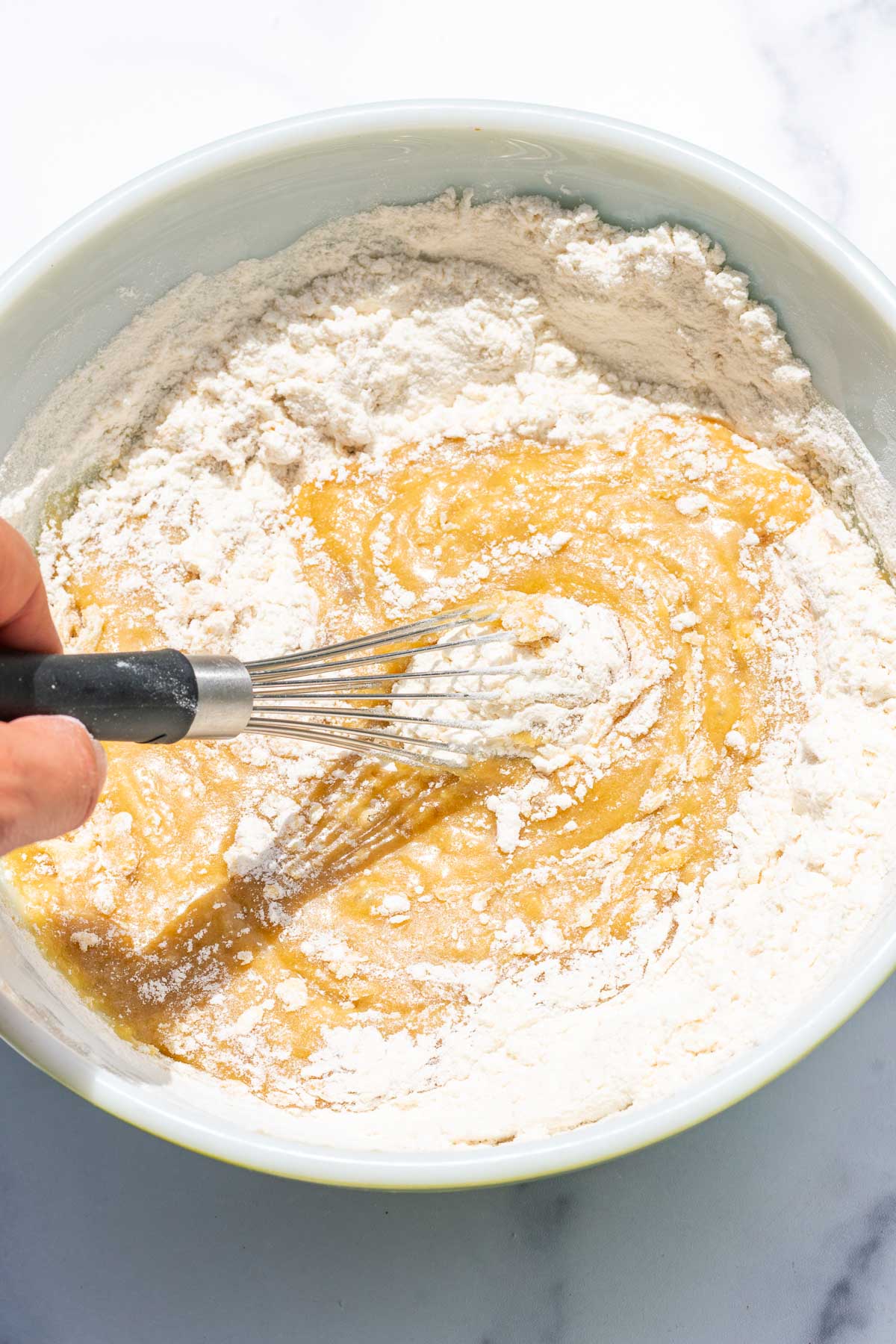 Whisking dry ingredients into wet ingredients in bowl