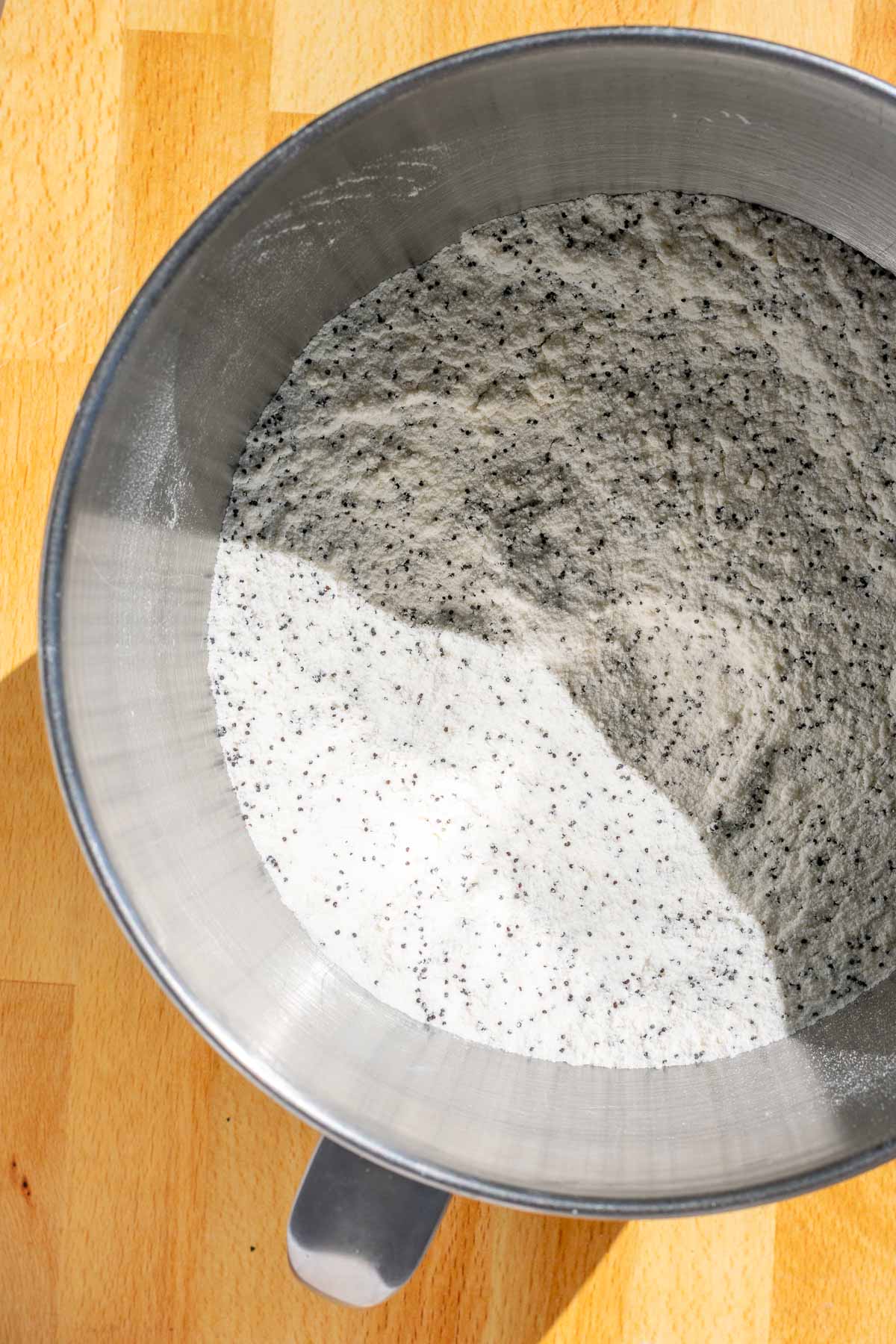 Dry ingredients for sourdough lemon poppy seed bundt cake in bowl of stand mixer