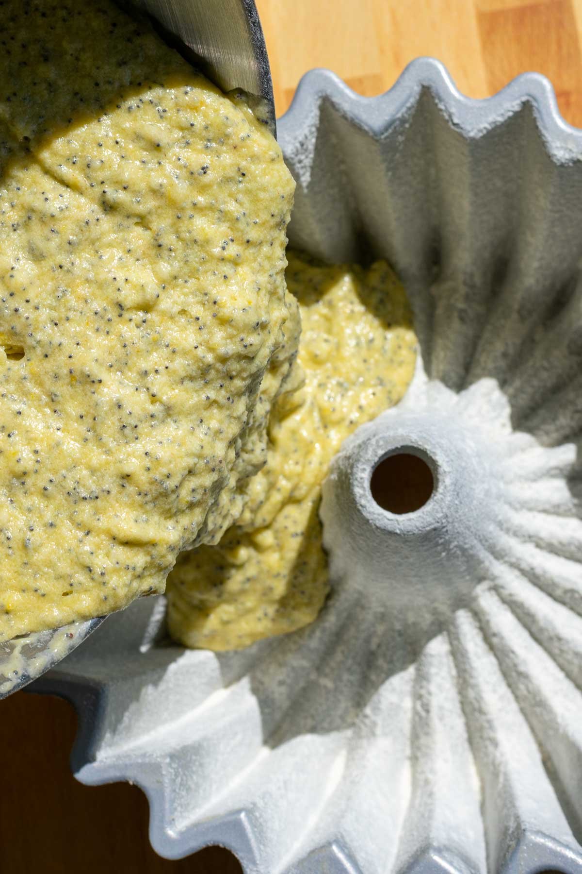 Pouring bundt cake batter into prepared bundt pan