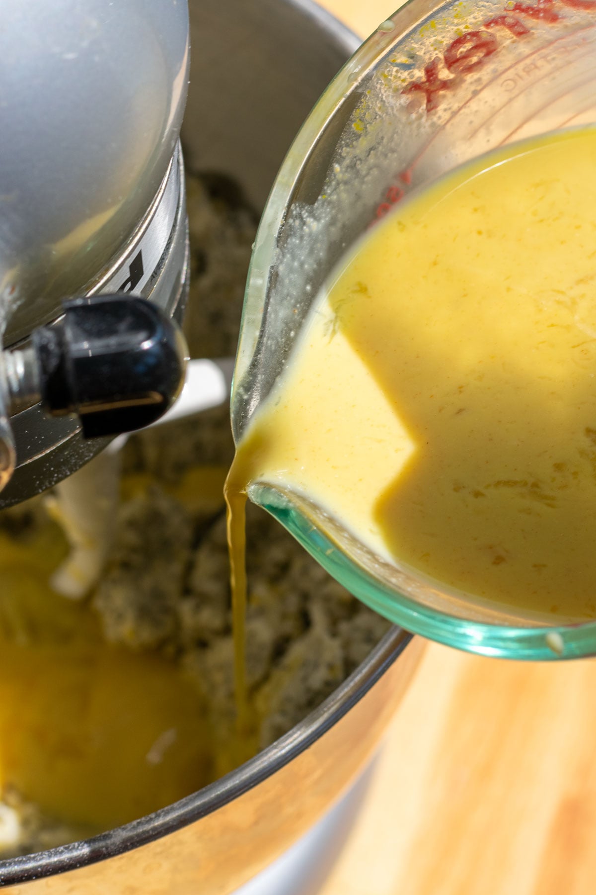 Pouring wet ingredients into the bowl of a stand mixer