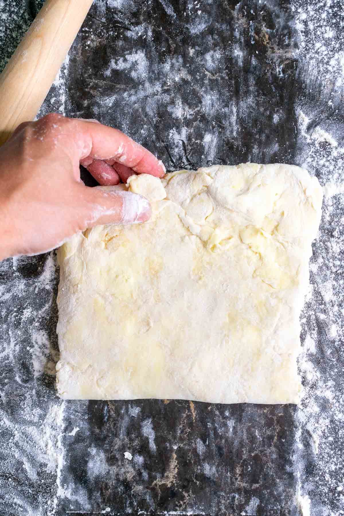 Folding the bottom third of the dough up and over like a business letter