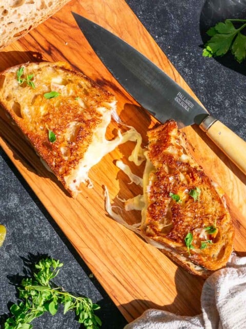Sourdough grilled cheese on a cutting board with a knife