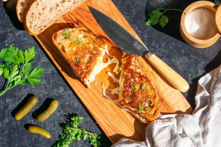 Sourdough grilled cheese on a cutting board with a knife