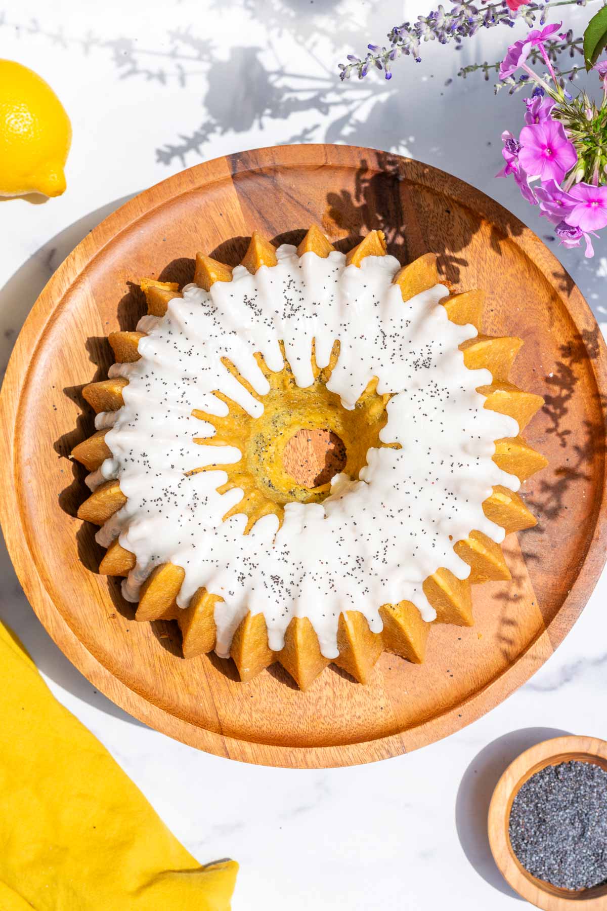 Glazed sourdough lemon poppy seed bundt cake on a cake stand