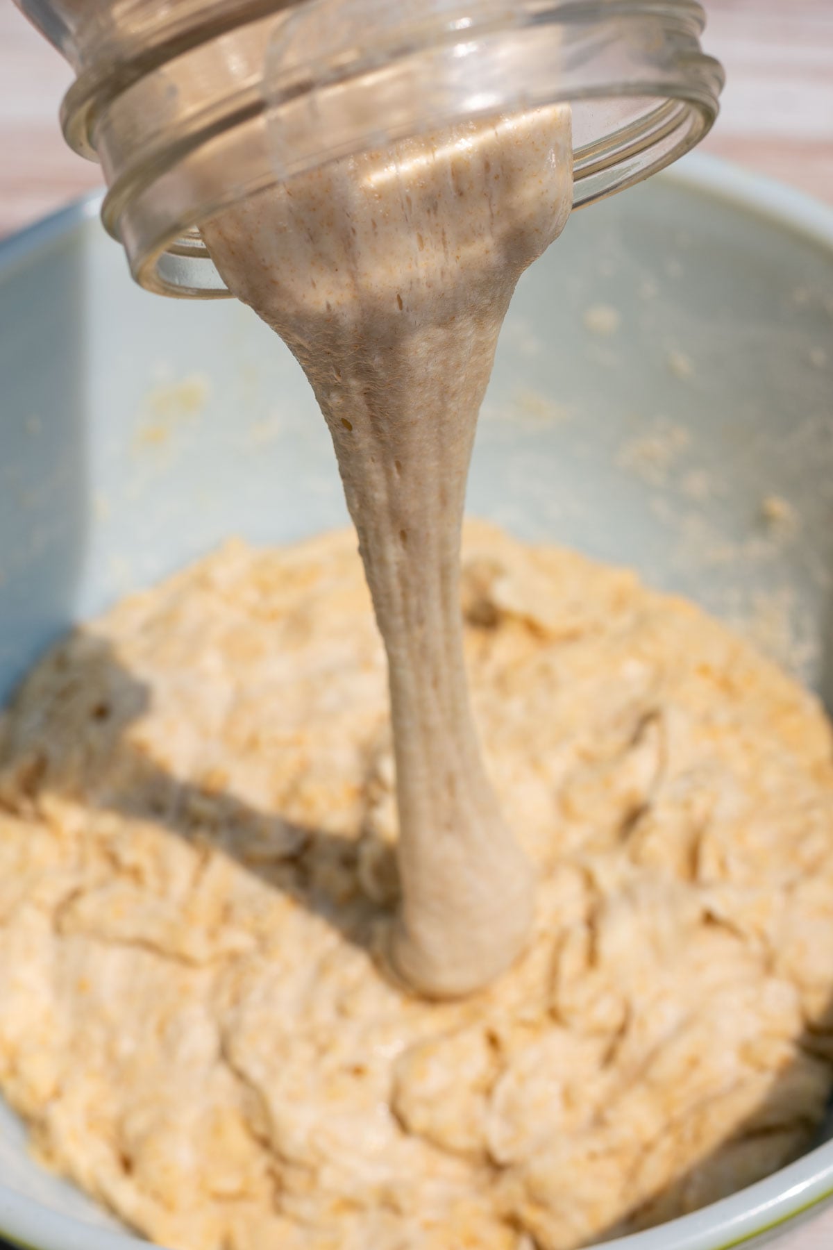 Pouring einkorn sourdough starter and levain into bowl