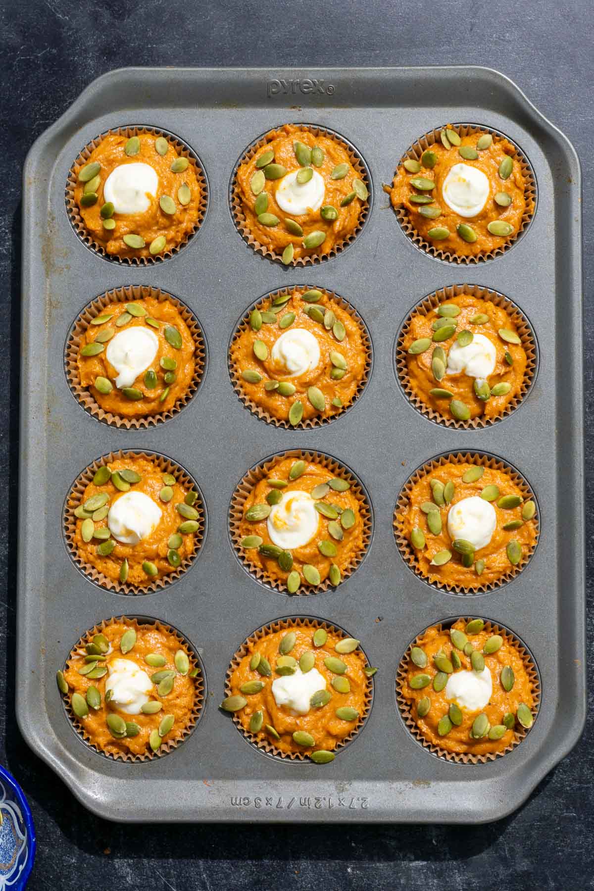 Baked sourdough pumpkin cream cheese muffins in a muffin pan.