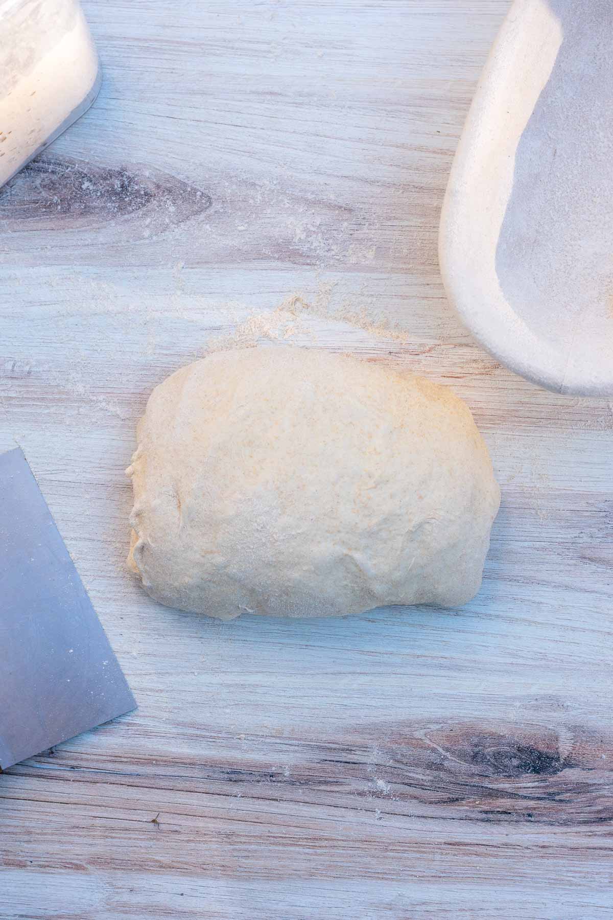 Shaped einkorn sourdough bread with a bench scraper