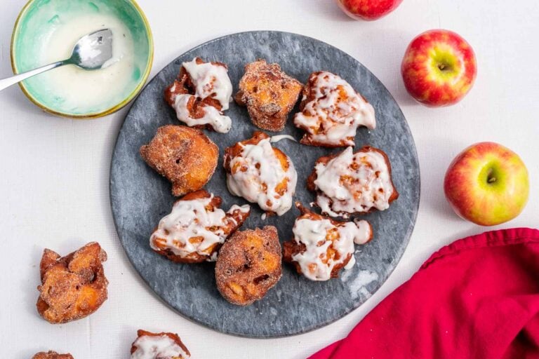 Sourdough apple fritters with glaze and cinnamon sugar on a serving platter